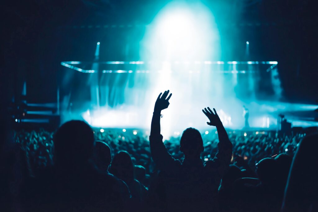 High-energy live music concert with crowd and vibrant stage lighting creating a dramatic atmosphere.